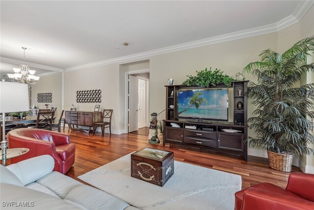 living room with dark hardwood / wood-style floors, ornamental molding, and a notable chandelier