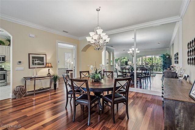 dining area with dark hardwood / wood-style flooring, ornamental molding, and a chandelier