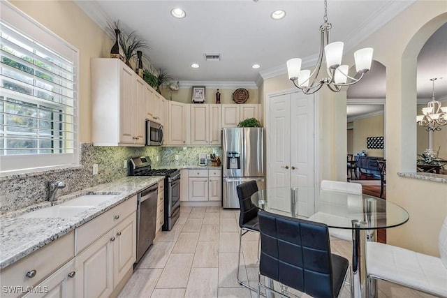 3189 Aviamar Cir Unit 202, Naples, FL 34114 - kitchen with appliances with stainless steel finishes, a chandelier, a sink, arched walkways, and light stone counters
