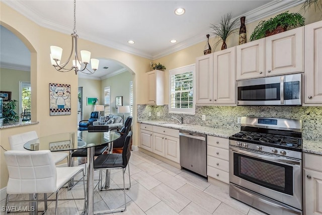 3189 Aviamar Cir Unit 202, Naples, FL 34114 - kitchen featuring stainless steel appliances, tasteful backsplash, a chandelier, a sink, and ornamental molding
