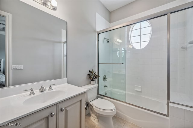 full bathroom with tile patterned floors, vanity, toilet, and combined bath / shower with glass door