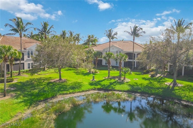 3189 Aviamar Cir Unit 202, Naples, FL 34114 - back of house featuring a lawn, a tiled roof, stucco siding, and a water view