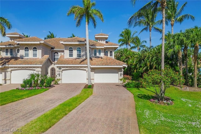 3189 Aviamar Cir Unit 202, Naples, FL 34114 - mediterranean / spanish-style house featuring decorative driveway, an attached garage, stucco siding, a front lawn, and a tile roof