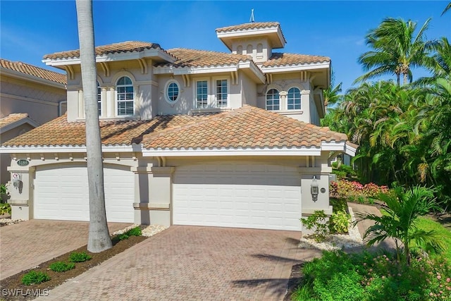 3189 Aviamar Cir Unit 202, Naples, FL 34114 - mediterranean / spanish-style home featuring a tiled roof, decorative driveway, and a garage