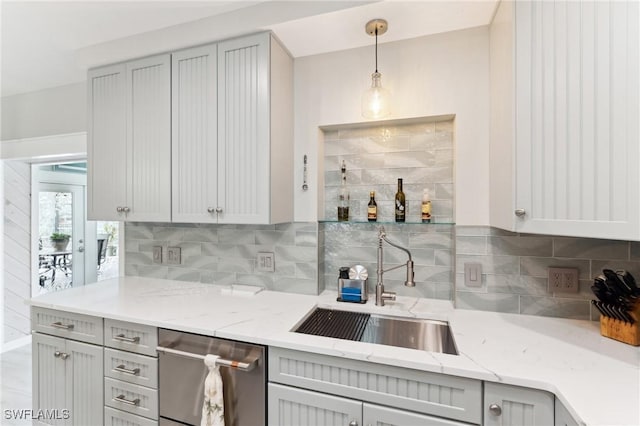 kitchen with tasteful backsplash, decorative light fixtures, stainless steel dishwasher, and gray cabinetry