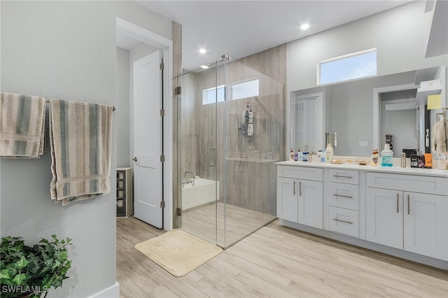 bathroom with a shower with shower door, wood-type flooring, and vanity