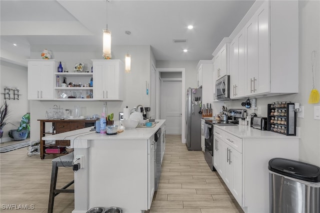 kitchen with sink, hanging light fixtures, stainless steel appliances, light hardwood / wood-style flooring, and white cabinets