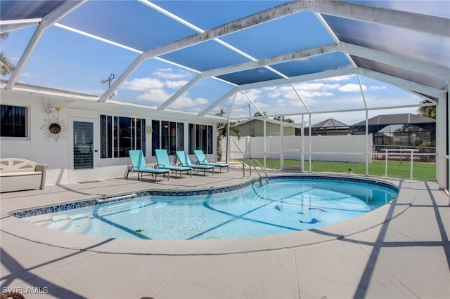 view of pool featuring a lawn, a fenced in pool, glass enclosure, fence, and a patio area