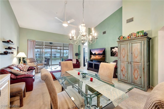 carpeted dining area featuring high vaulted ceiling and ceiling fan with notable chandelier