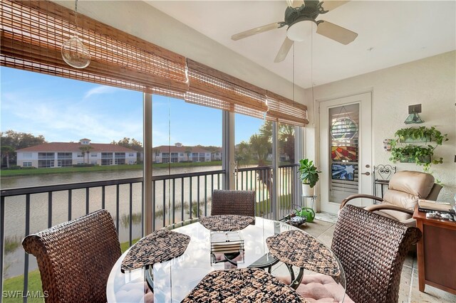 sunroom / solarium with a water view and ceiling fan