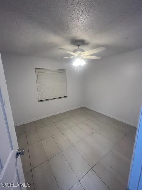 unfurnished room featuring ceiling fan and a textured ceiling