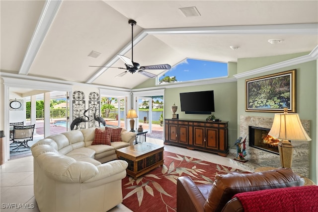 living room featuring vaulted ceiling, ceiling fan, light tile patterned flooring, and a fireplace