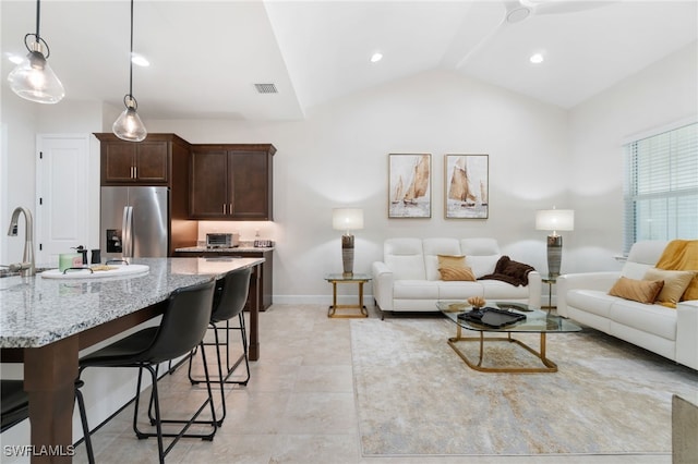 living room with ceiling fan, light tile patterned floors, and vaulted ceiling