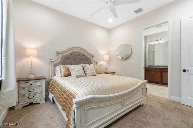 carpeted bedroom featuring ensuite bath, ceiling fan, and sink