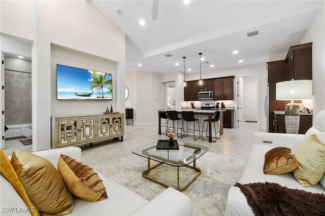 living room featuring light tile patterned flooring and high vaulted ceiling