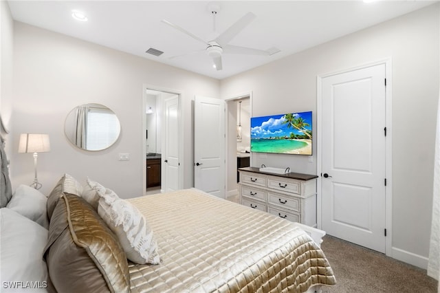 carpeted bedroom with ceiling fan and ensuite bath