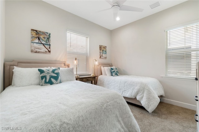 bedroom with multiple windows, ceiling fan, and carpet