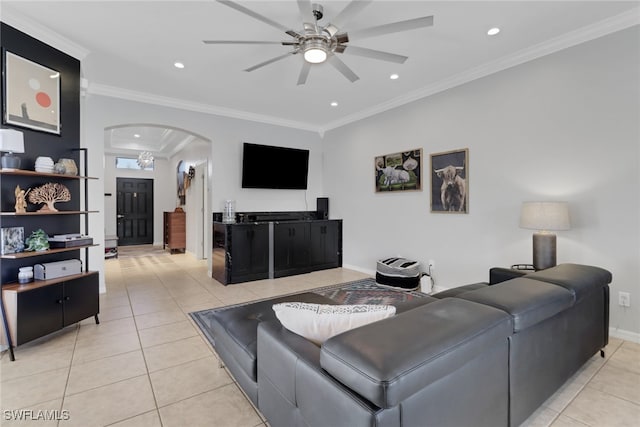 tiled living room with ceiling fan and crown molding