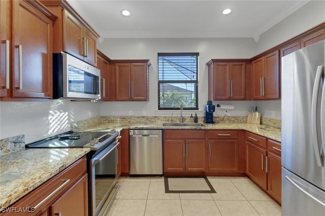 kitchen featuring light stone countertops, a healthy amount of sunlight, sink, and stainless steel appliances