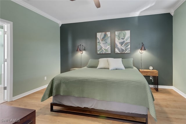 bedroom with light hardwood / wood-style floors, ceiling fan, and ornamental molding