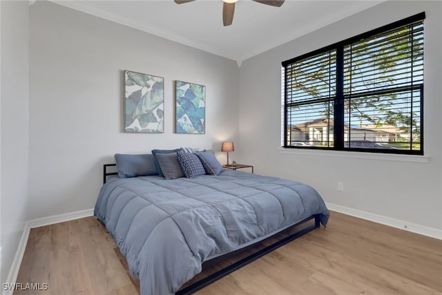 bedroom featuring hardwood / wood-style flooring, ceiling fan, and crown molding