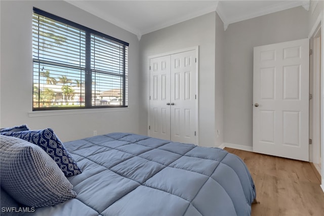 bedroom featuring crown molding, a closet, and light hardwood / wood-style floors