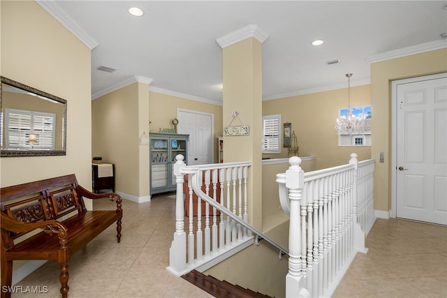 hallway with a chandelier, light tile patterned floors, and crown molding