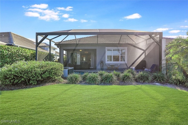 back of house with a lanai and a lawn