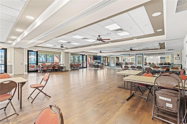 interior space with visible vents, a tray ceiling, and wood finished floors