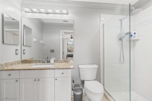 bathroom featuring ornamental molding, a tile shower, vanity, and toilet