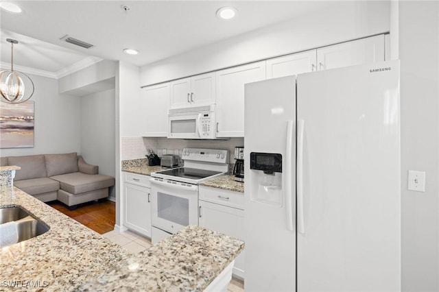 kitchen featuring white appliances, light stone countertops, visible vents, and white cabinetry