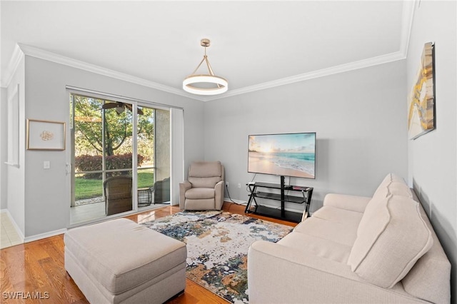 living room with ornamental molding, baseboards, and wood finished floors