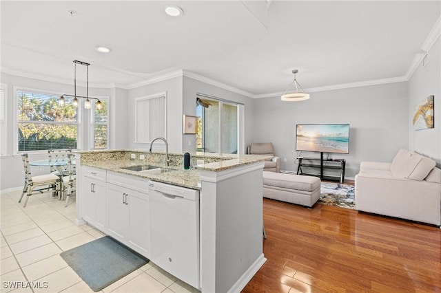 kitchen with dishwasher, ornamental molding, open floor plan, and a sink