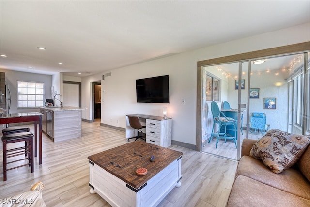 living room featuring light hardwood / wood-style floors and sink