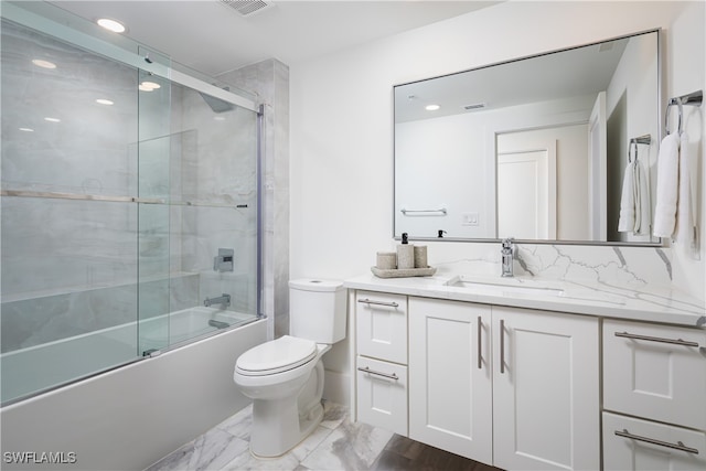 full bathroom featuring vanity, enclosed tub / shower combo, and toilet