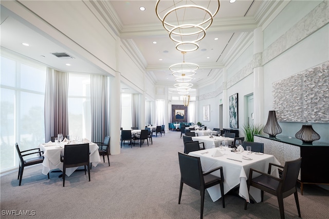 carpeted dining area with crown molding and a chandelier