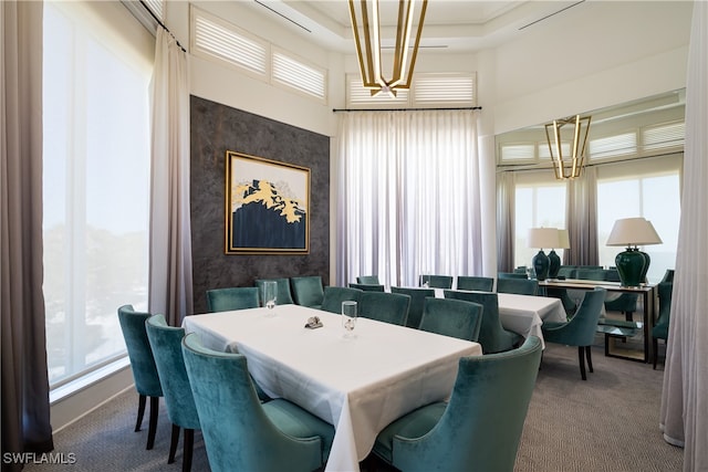 carpeted dining area featuring a high ceiling and a healthy amount of sunlight