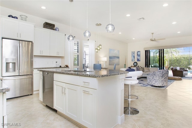 kitchen featuring appliances with stainless steel finishes, white cabinetry, and a healthy amount of sunlight