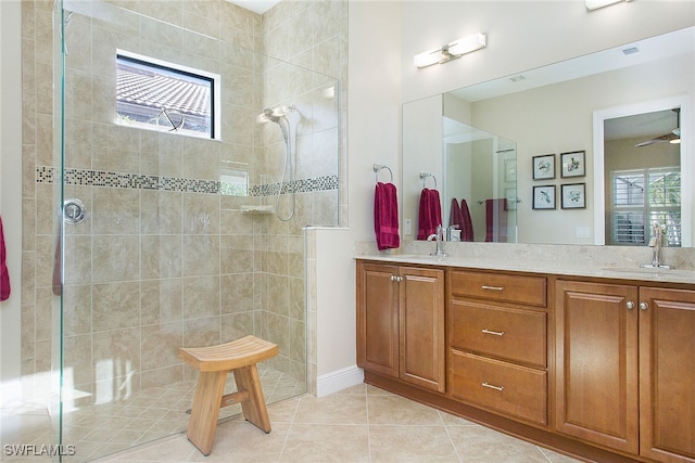 bathroom featuring tile patterned flooring, vanity, a healthy amount of sunlight, and walk in shower