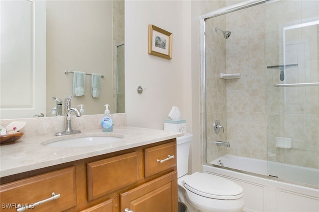 full bathroom featuring vanity, toilet, and bath / shower combo with glass door