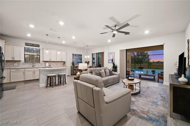 living room featuring ceiling fan and sink