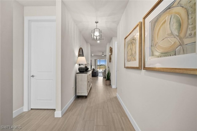 hallway with an inviting chandelier