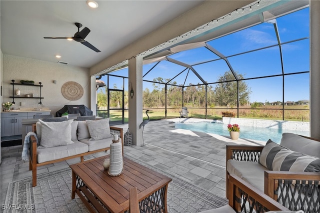 view of patio with outdoor lounge area, ceiling fan, and glass enclosure