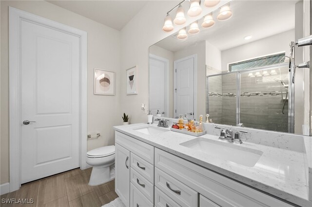 bathroom featuring toilet, vanity, and walk in shower