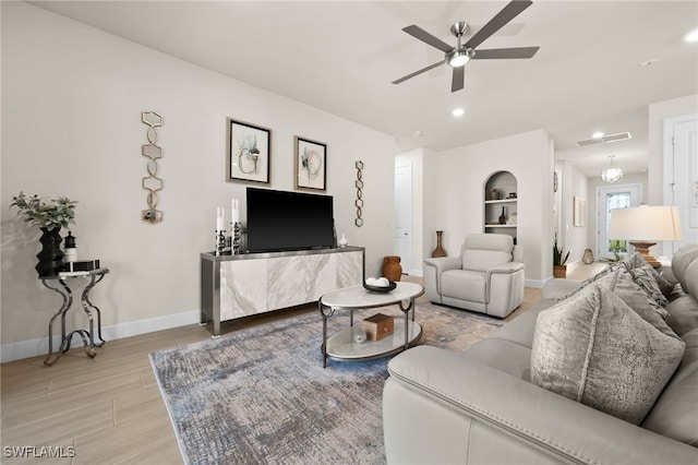 living room with ceiling fan and built in features