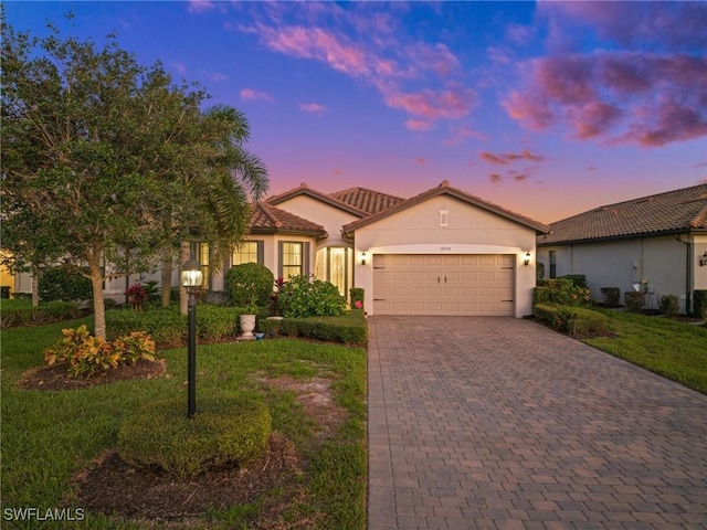 view of front facade featuring a garage and a lawn