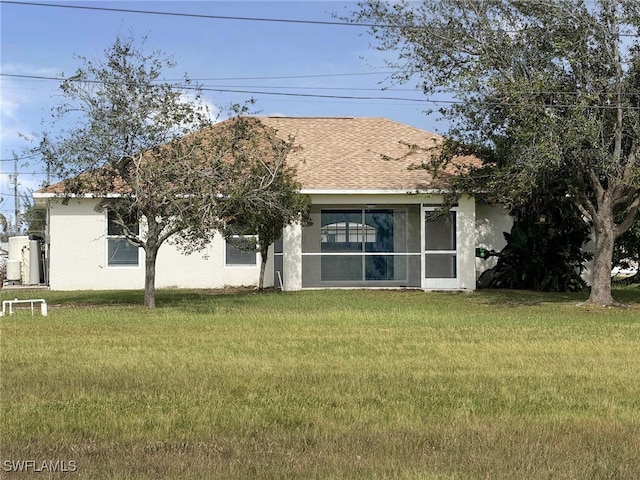 view of front of property featuring a sunroom and a front lawn