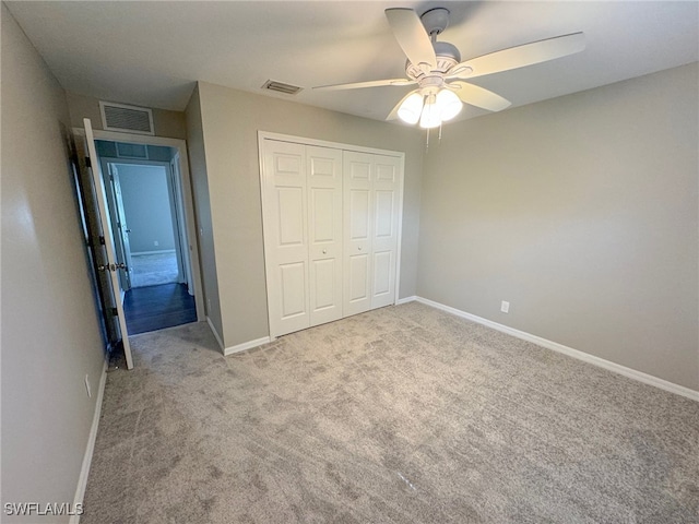 unfurnished bedroom with light colored carpet, a closet, and ceiling fan