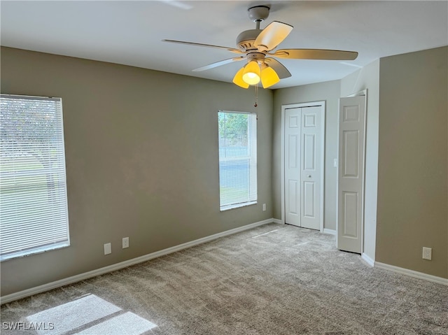 unfurnished bedroom with ceiling fan, a closet, and light colored carpet