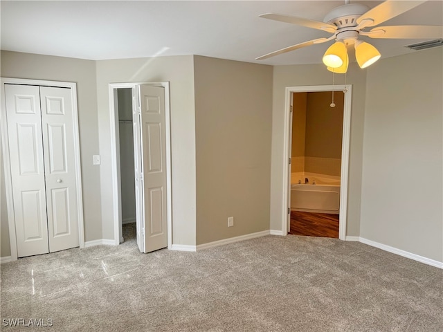 unfurnished bedroom featuring ensuite bathroom, ceiling fan, and light colored carpet